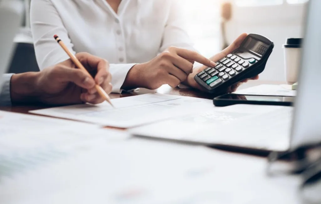 Cálculos em papeis e calculadora sobre a mesa