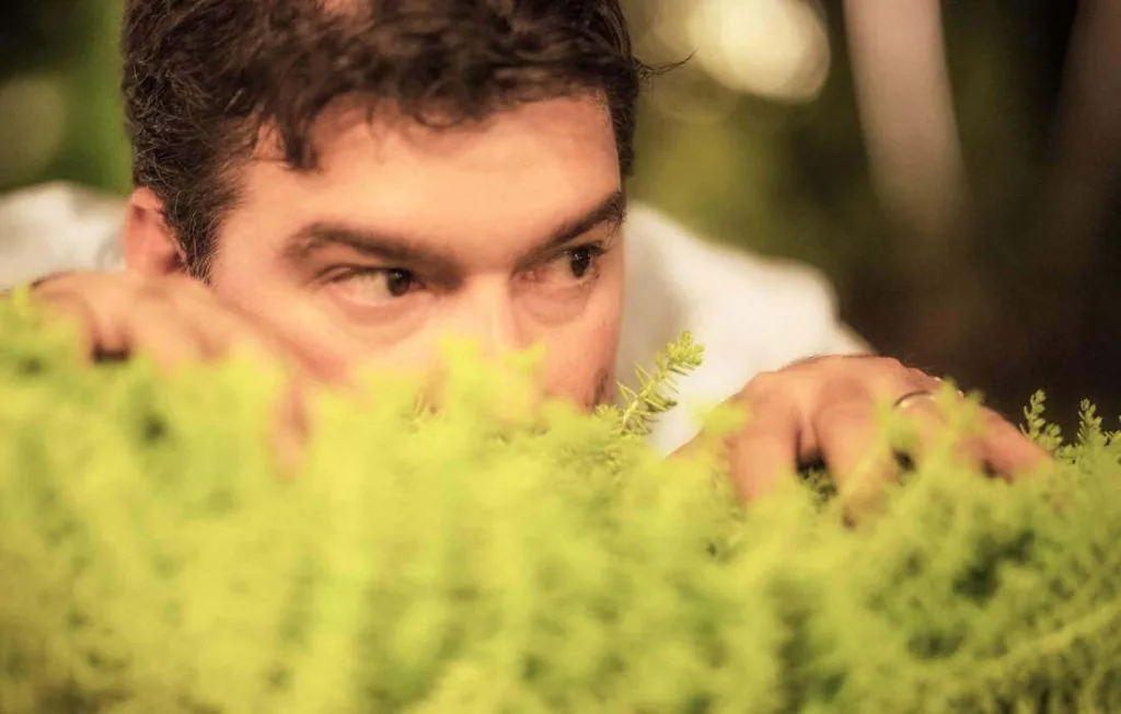 Vizinho de Câncer olhando por cima das plantas